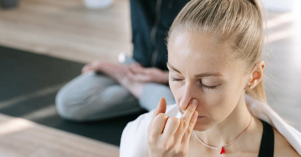 Person sitzt in ruhiger Umgebung und praktiziert bewusstes Atmen