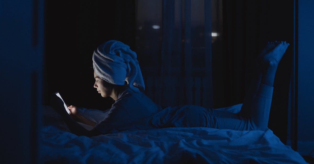 Smartphone liegt neben einem Bett in einem abgedunkelten Schlafzimmer