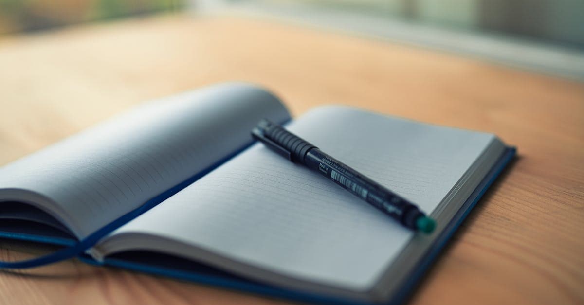 Offenes Notizbuch mit Stift auf einem ruhigen Schreibtisch neben einer Tasse Tee