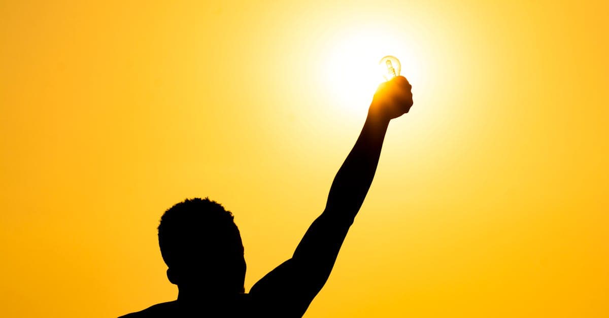 Person lächelt in der Natur mit Sonnenlicht im Hintergrund