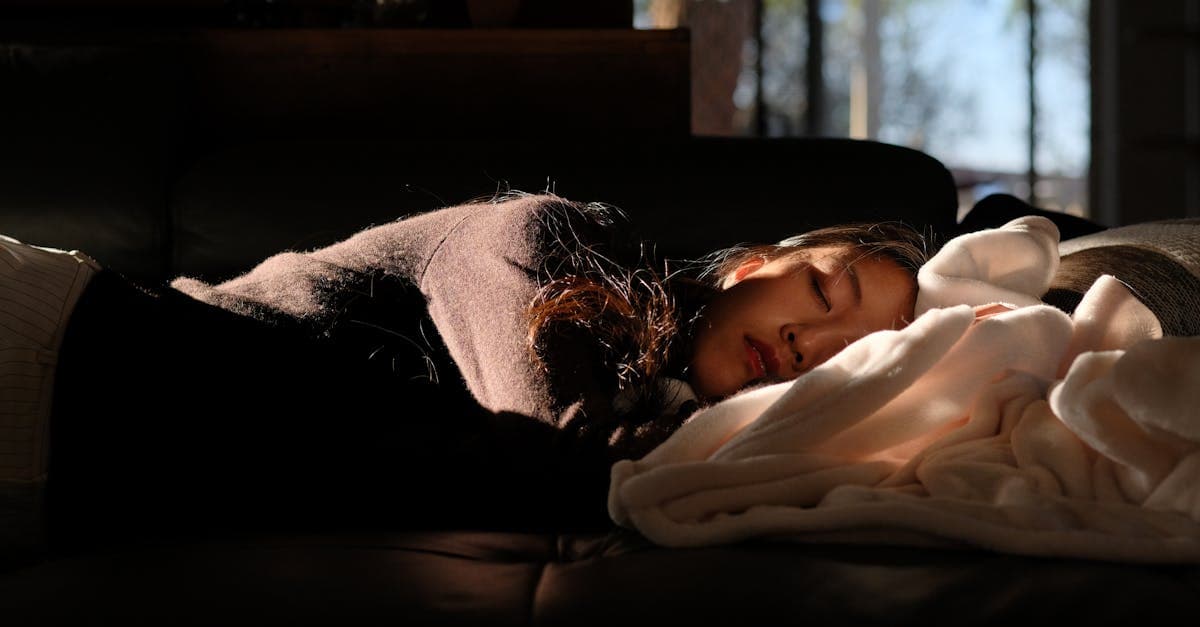 Person macht ein kurzes Nickerchen auf dem Sofa in einem hellen Raum