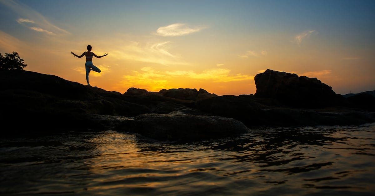 Person steht auf einem Berggipfel und blickt in die Weite
