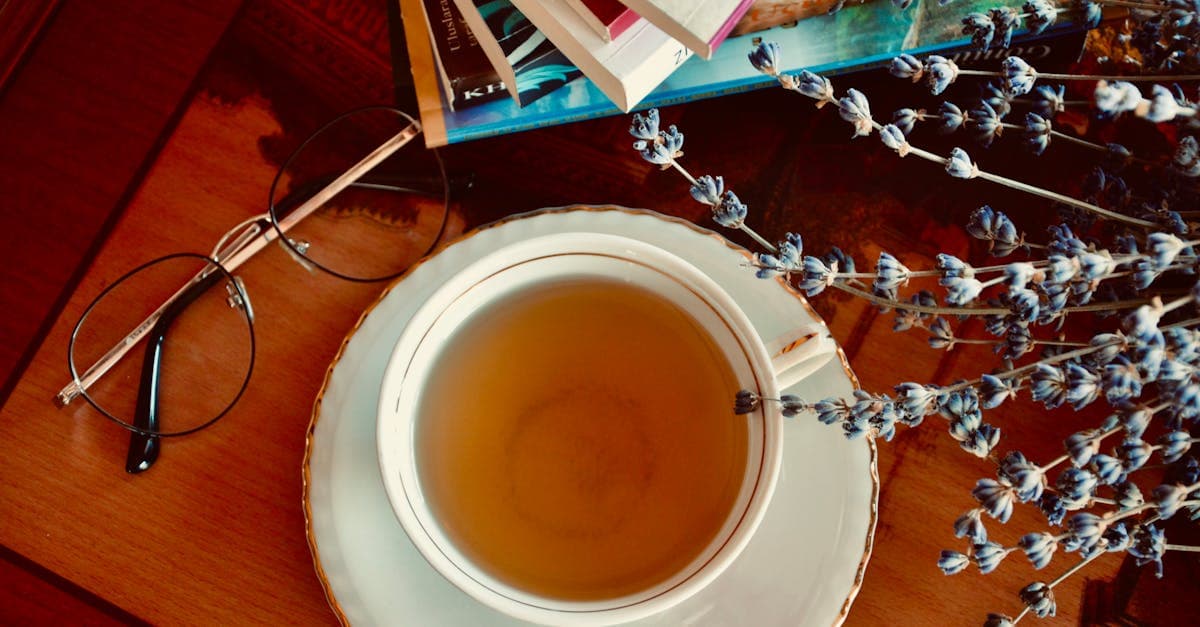 Kräutertee und Lavendelzweige auf einem Nachttisch neben einem Bett