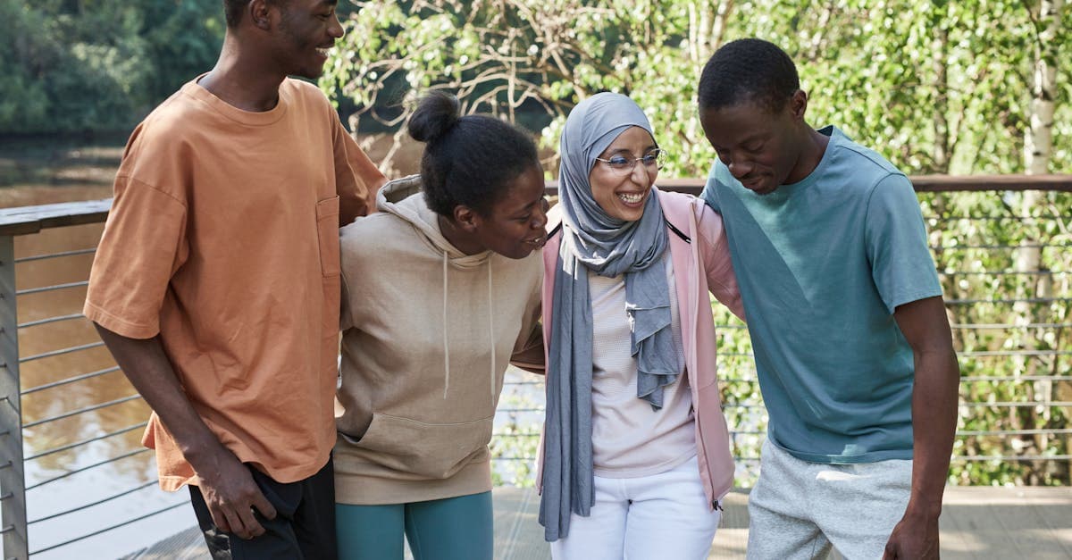 Gruppe von Freunden lachend in einem Park bei Sonnenschein