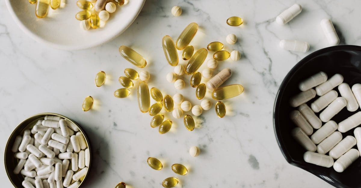 Verschiedene Supplement-Kapseln und -Tabletten neben frischem Obst und Gemüse