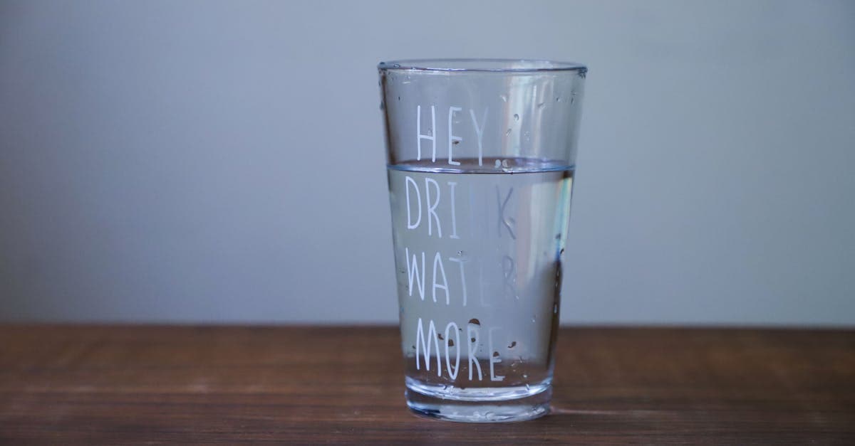 Glaskaraffe und Glas mit frischem Wasser und Zitronenscheiben auf einem Tisch